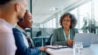 Three people sitting at a table talking.